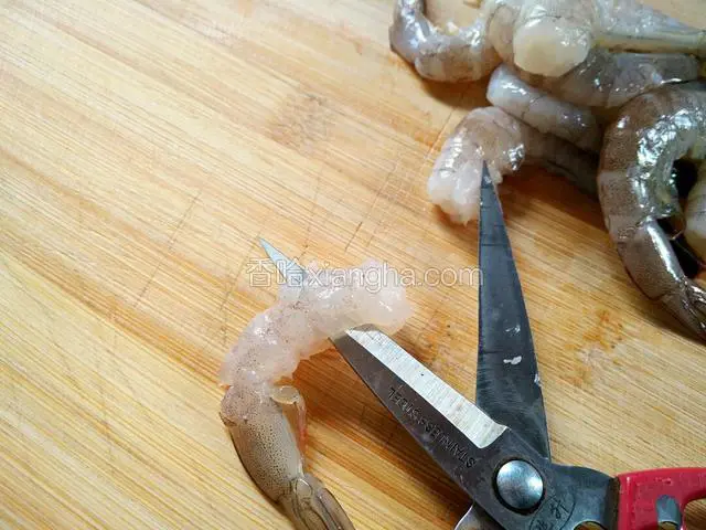 再将虾肉头部的一端，用尖刀或剪刀穿透以便虾尾穿过去。
