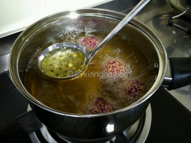 很快，紫薯球会漂浮上来，用勺子轻轻按压几次。