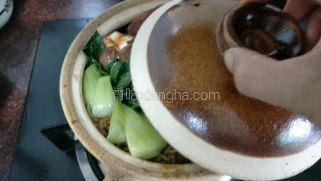把青菜和葱放上去，盖上砂锅盖小火煮大概1分钟后熄火