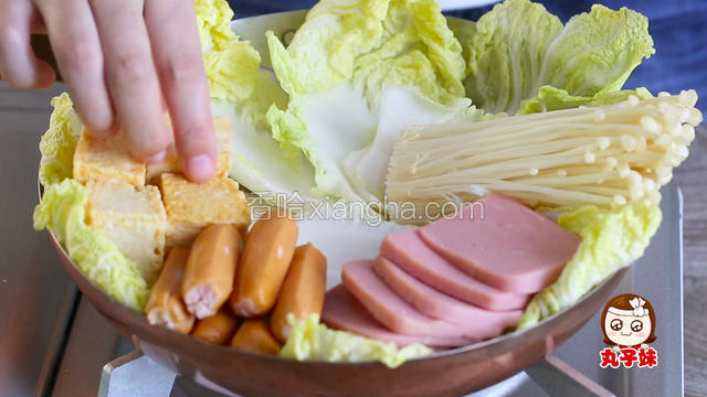 先用洋葱铺底，白菜铺在四周，上面依次铺放好其他的配菜