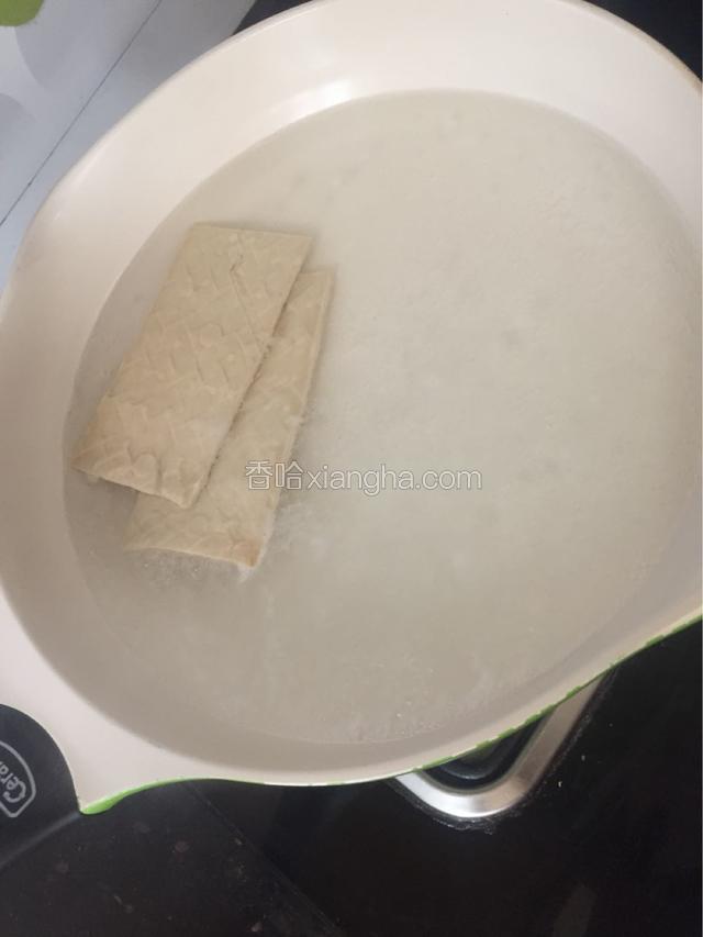 煮半锅开水，把两块白豆腐干放入加半勺盐，煮2分钟，捞出过凉，