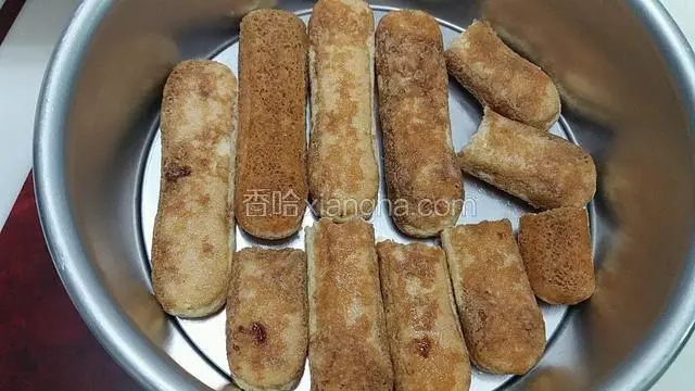 手指饼干在酒、咖啡混合的液体中正反蘸下，铺到模具底部，尽量铺满
