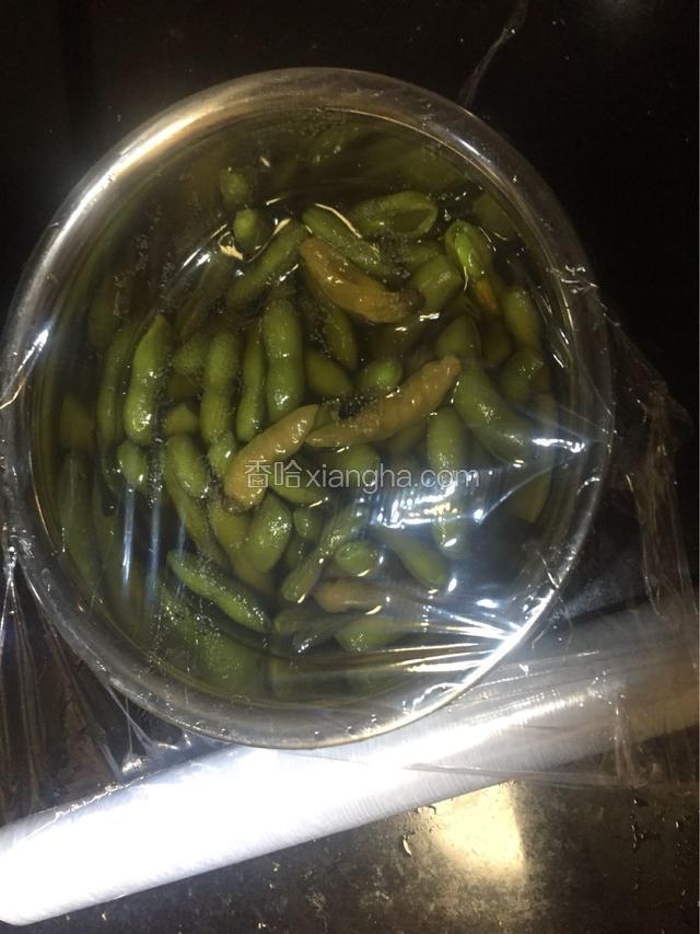 卤水泡着的豆角用保鲜膜封好，放入冰箱冷藏两小时以上，