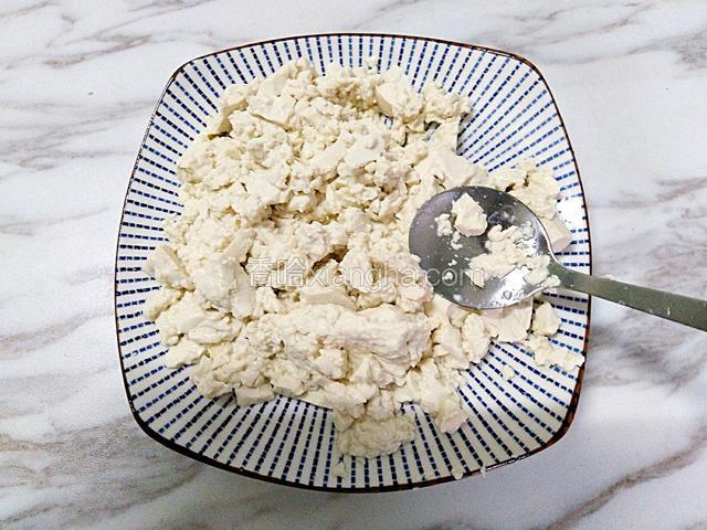 先用勺子把豆腐压碎，待用