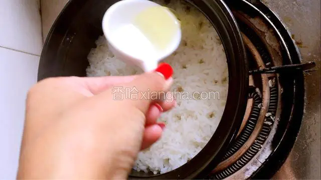 米饭煮到8分熟（其小孔的时候），沿着边缘淋入一勺色拉油