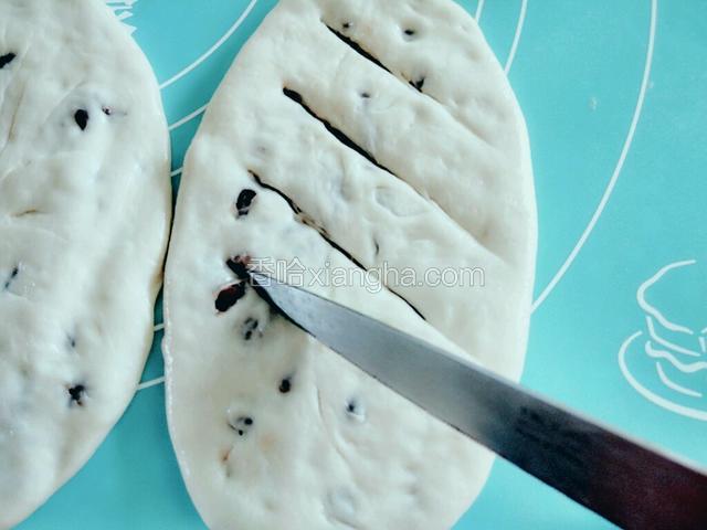 将豆沙饼慢慢擀成牛舌状，用刀在饼上划均匀的斜刀。