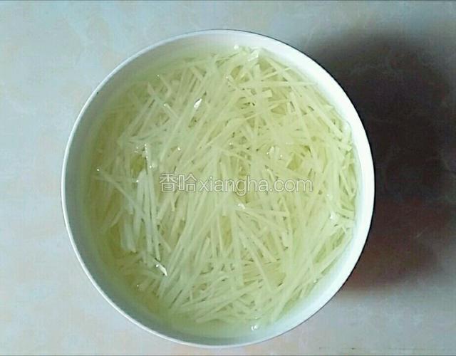 土豆削皮洗净切丝，用清水漂洗两三遍，再把土豆丝放清水里，倒一勺白醋漂三分钟捞起待用。