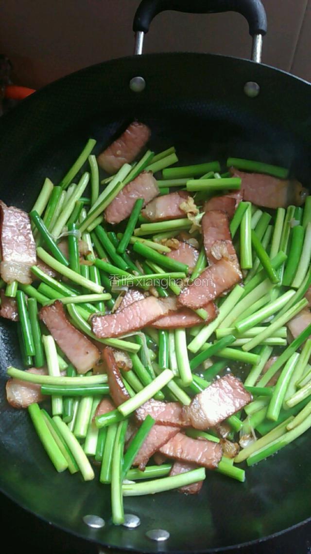 下蒜苔翻炒出香味，加少量酱油翻炒均匀，再下开水翻炒均匀，盖锅盖焖2分钟，再开盖翻炒均匀，焖2分钟