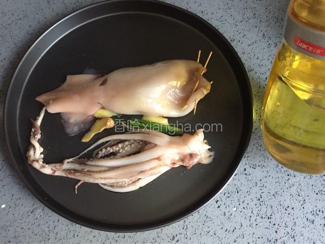 鱿鱼两面撒少许料酒，均匀抹上少许油，