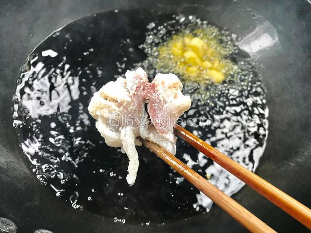 用筷子，将鱼肉的皮面卷紧成一团，成花蒂，放入油锅中