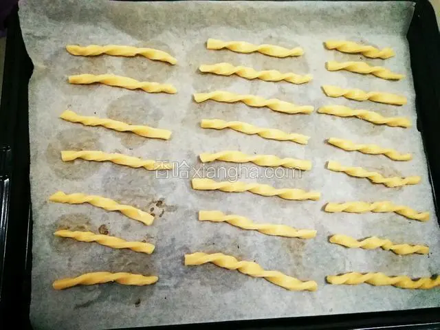 用小刀切成自己喜欢的长度和宽度，用左右手顺时针和逆时针方向拧成螺丝形，刷上蛋液。
