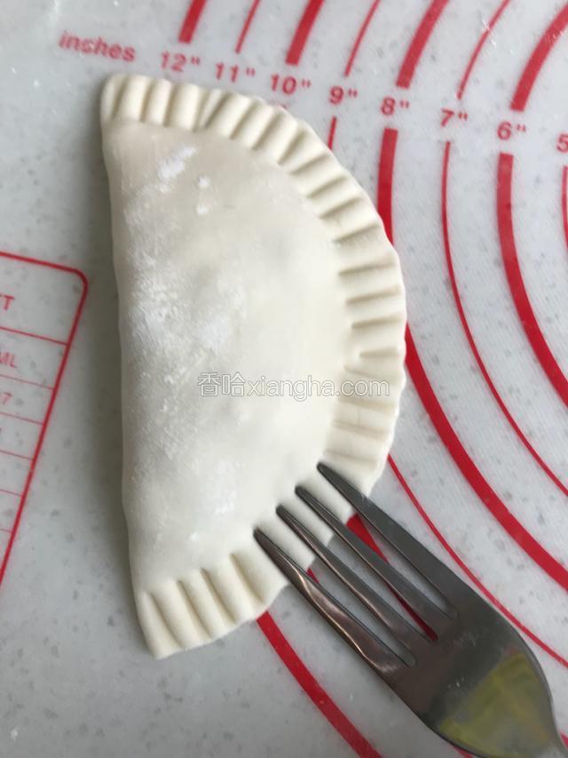 对折成饺子形状，用叉子压面皮边