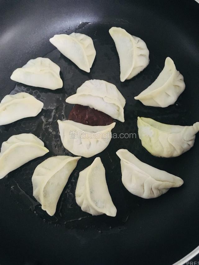 把饺子排放在锅里，开中小火慢慢煎制饺子