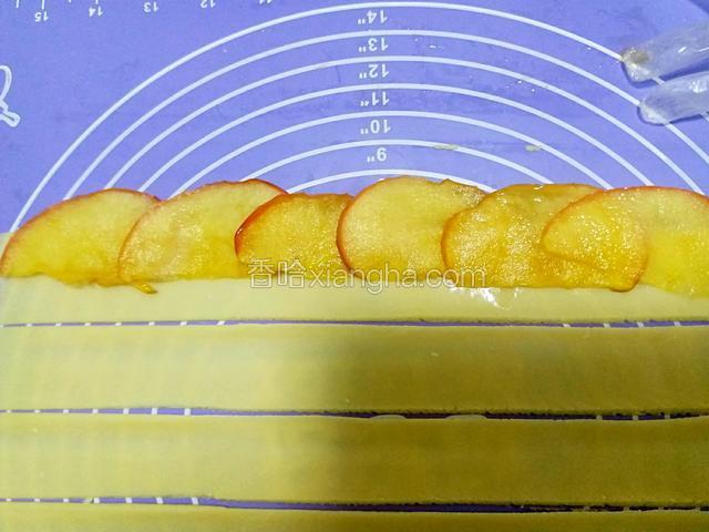 苹果片冷却后取其中七片，依次层叠放入一条宽面条上。（如图）