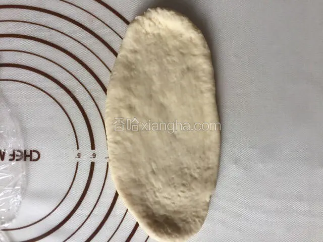 取出一个面团擀开成长舌状椭圆形