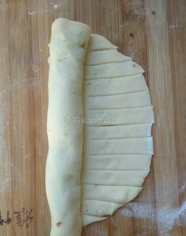 将豆沙一头卷起来，留出没有豆沙的面，用刀均匀切成条状