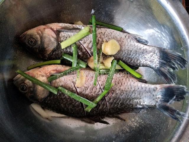 在鱼身上划几刀为了更好的入味，然后放少许葱姜，胡椒粉，料酒腌十几分钟，