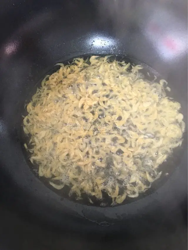 锅下入油烧至三成热时倒入虾皮爆香