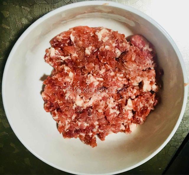 将猪肉剁成肉末装入碗中。