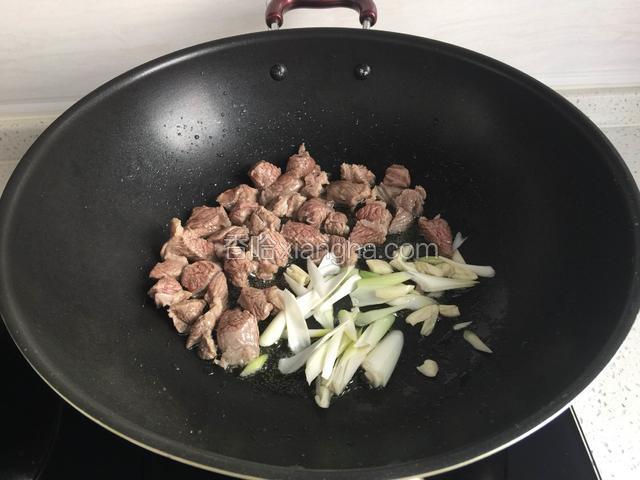 锅烧热倒入牛肉炒干水份，加入油，葱，蒜炒香。