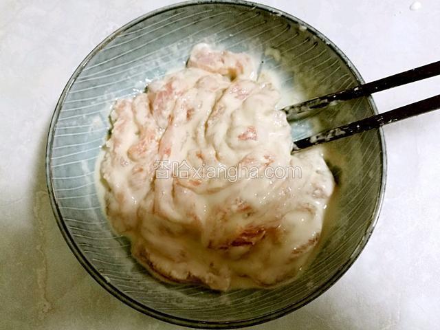 把淀粉糊倒入肉里拌匀，使每一条肉都裹上淀粉糊。