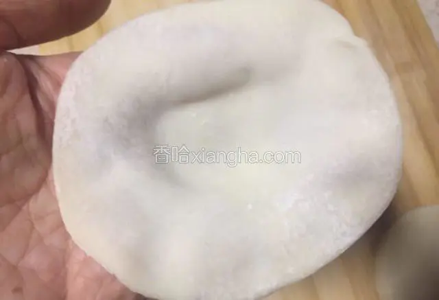 准备一张饺子皮，沿皮的边缘拉一下