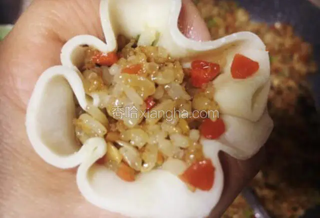放在左手的虎口上，舀入适量的糯米饭