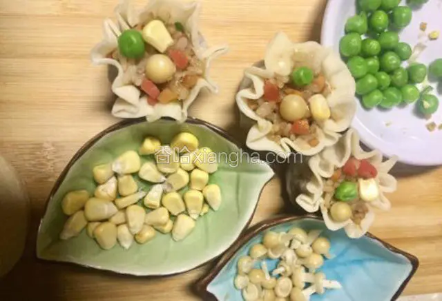 接着把烧卖边缘翻下来，成花边再将玉米粒青豆，金针菇头装饰在上面