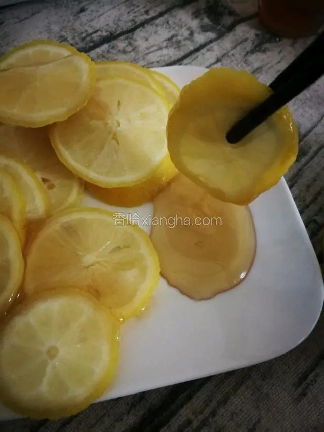 在碟子上倒一些蜂蜜，每片柠檬都沾上蜂蜜。