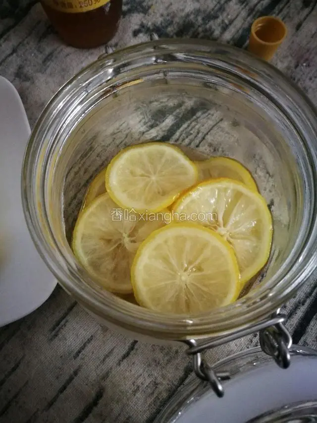 密封罐底成铺一层蜂蜜然后放上沾了蜂蜜的柠檬片，重复2-3步骤直到所有柠檬片放完。