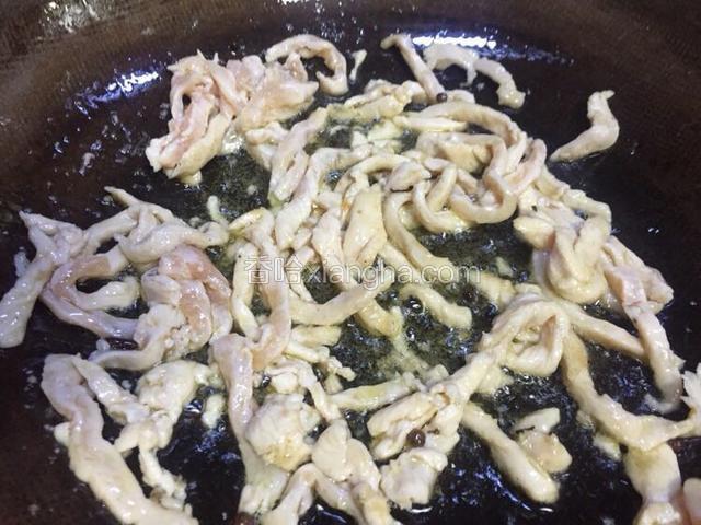 七成热时倒入鸡肉丝快速翻炒至变白