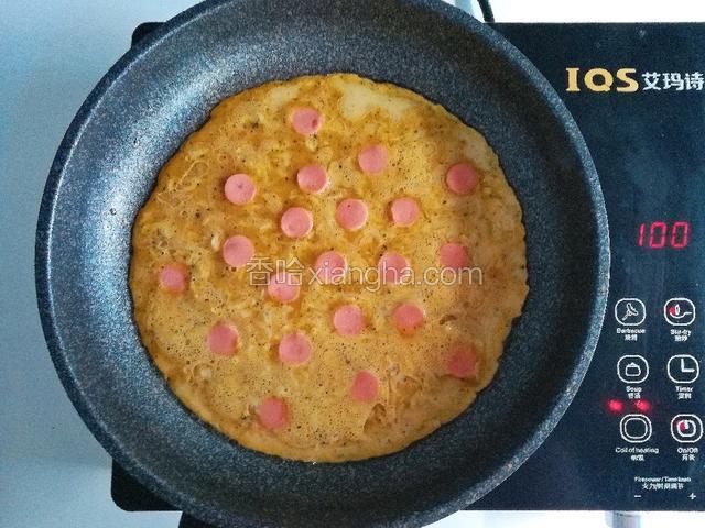 起锅热油，倒入蛋糊，未凝固时摆上火腿片压紧，小火烙至两面熟透即可出锅