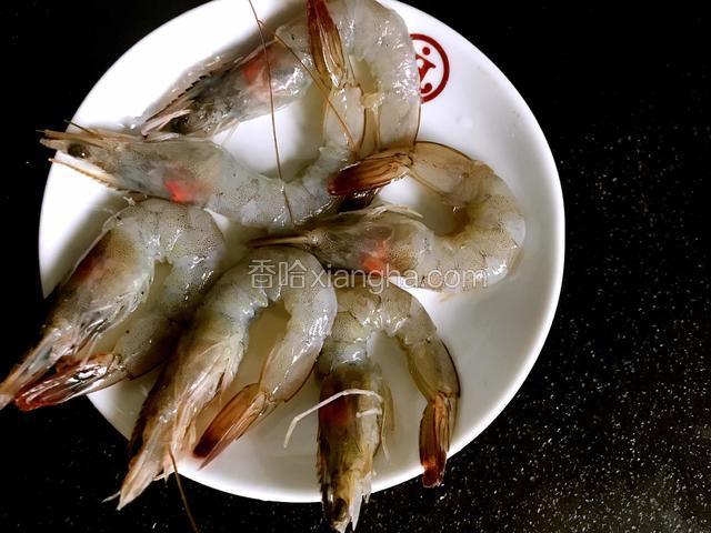 将基围虾洗净，挑出虾线，剥去虾身的皮，留头和尾