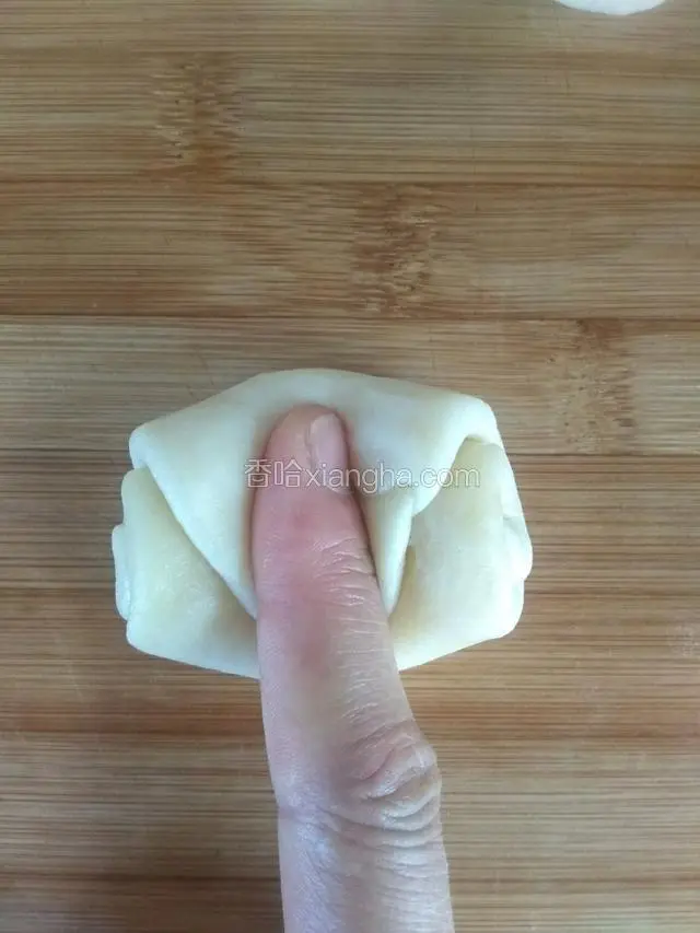 把醒发好的，取一个，用手在中间压下