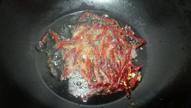 油热放入花椒和红辣椒煸出香味。