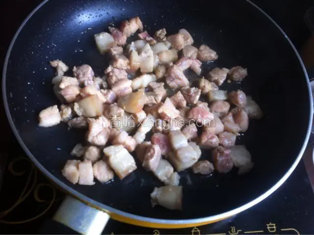 然后放入腌制的肉丁炒至变色