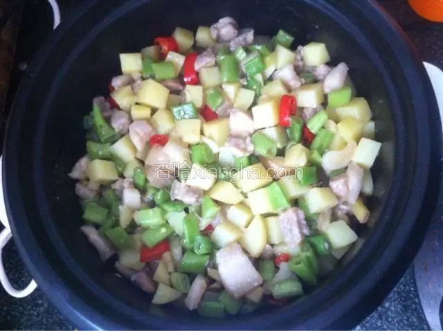 把炒好的土豆豆角放入锅中，均匀铺上