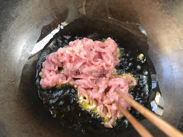 锅烧热油，油温六成热时加入腌制好的瘦肉，炒至变色