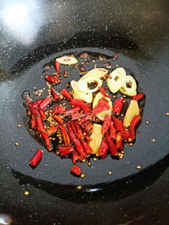 炒锅留底油，爆香葱姜，倒入辣椒段，花椒粒炒香