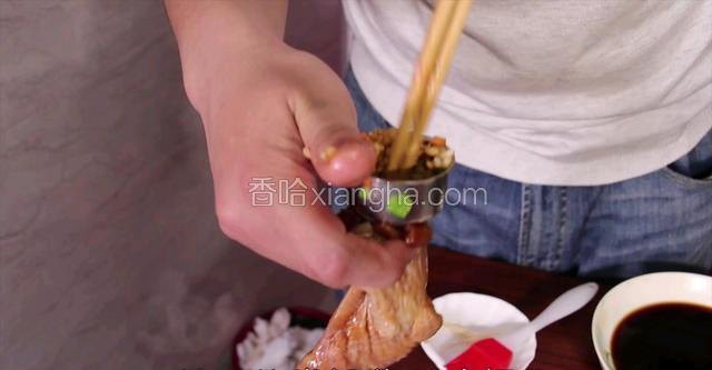 把腌好的鸡翅拿出，炒好的米饭放入鸡翅里(三分之二满，否则熟了会爆开)
满好的鸡翅用牙签封住