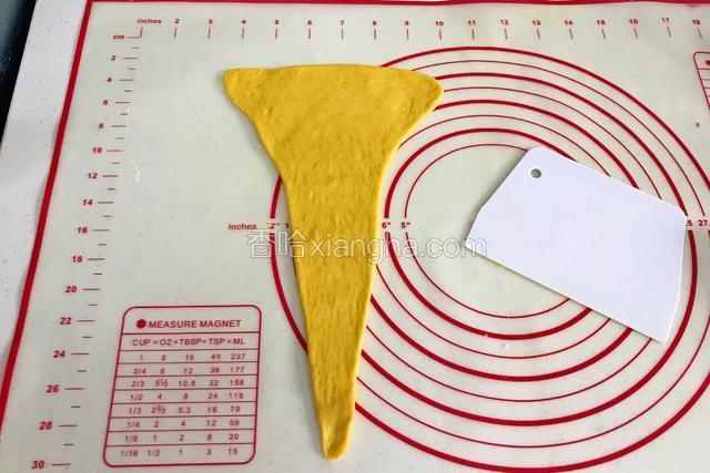 用擀面杖刚成长三角形状，上面宽的部分往两边擀开。