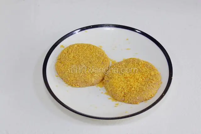 给压好的肉饼裹上面包糠。