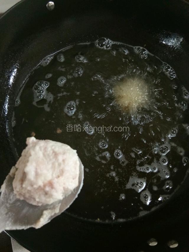 锅内放油烧制七成热时如图放入丸子。