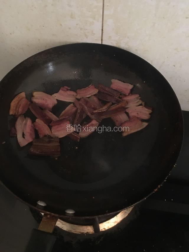 把熏肉放入热锅炒至肉卷，且有油溢出