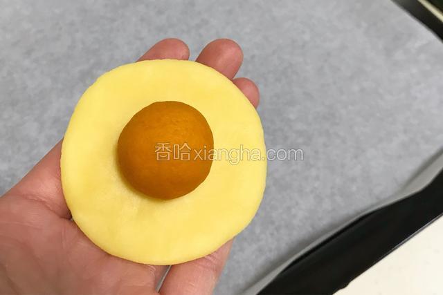 取一个小面团按扁，放上一份南瓜馅。