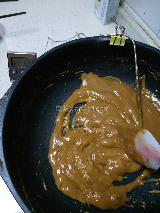 二十七分钟后状态，已接近我设置的温度125°，我拿了一根筷子蘸点糖浆往冰水里放几秒，取出用牙咬是硬的状态，然后我就关火，把坚果放到锅里面拌匀。