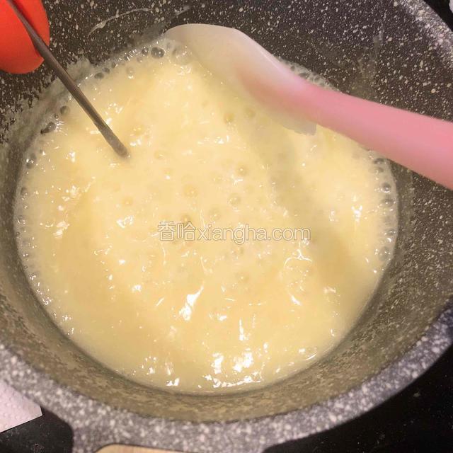 熬煮过程用刮刀来回搅拌底部，让所有材料混合更均匀，同时需要将粘在锅壁上的糖浆不断刮下来。