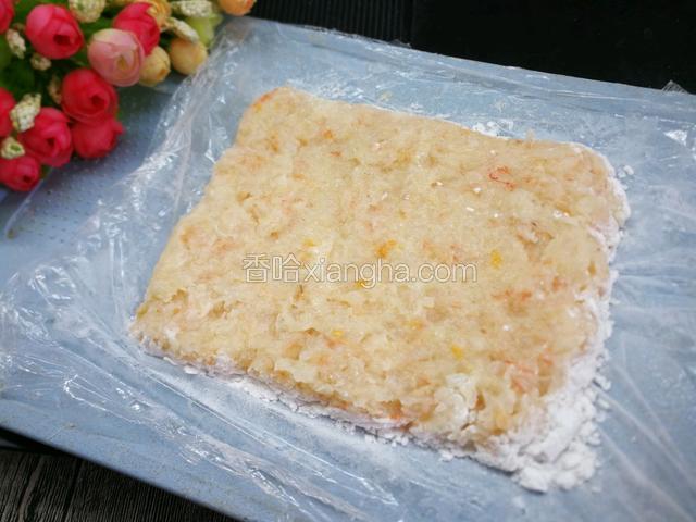 案上铺一层保鲜膜，把打好的虾泥铺在上边约1厘米厚。