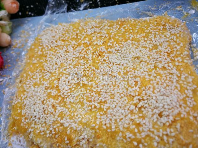 再把蛋黄打散慢慢刷一层，撒上一层芝麻仁。
