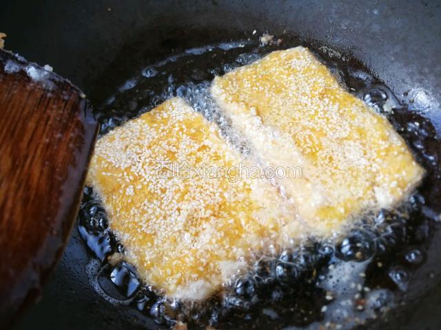 热锅冷油烧至五成热，放入虾饼，慢火煎至金黄。
